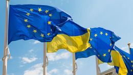 Die Flaggen der Ukraine und der Europäischen Union flattern im Wind am blauen Himmel.
